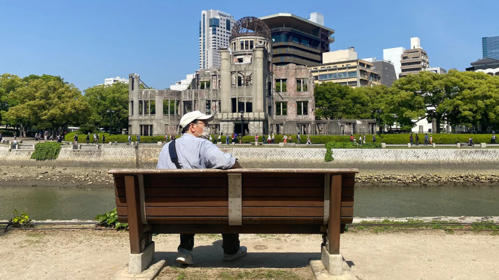 Un hombre se relaja junto al río en un banco con vista a la cúpula Genbaku. (Foto: Emiko Jozuka/CNN)